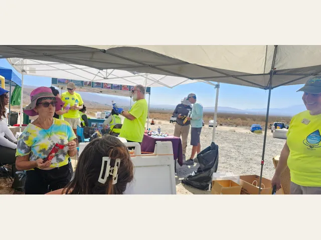 Volunteers gather under a shade canopy at the cleanup event.